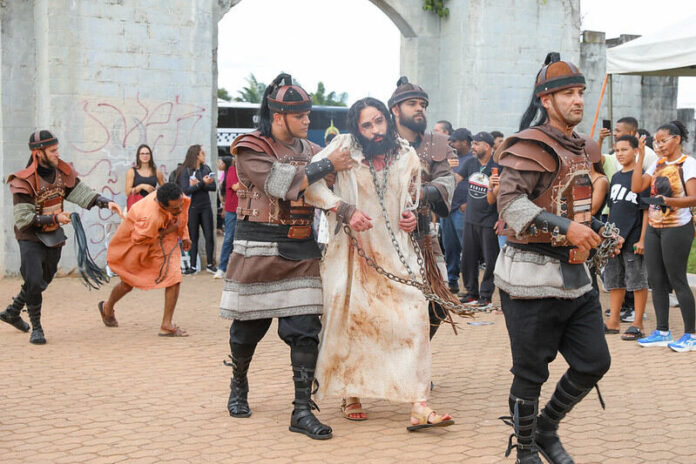 Imagem da encenação da Via-Sacra no Morro da Capelinha com multidão de fiéis no DF
